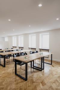 a classroom with tables and chairs in a room at Hotel Cristallo in Landshut