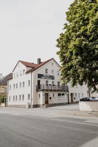 un bâtiment blanc sur le côté d'une rue dans l'établissement Hotel Cristallo, à Landshut