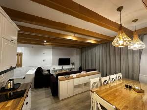 kuchnia i salon ze stołem i krzesłami w obiekcie AURA Centrum Wypoczynkowo-Rekreacyjne w Sejnach