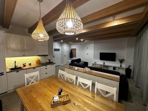 uma grande cozinha com dois lustres e uma mesa em AURA Centrum Wypoczynkowo-Rekreacyjne em Sejny