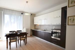 eine Küche mit einem Tisch und eine Küche mit weißen Schränken in der Unterkunft Appartamento Bellariva B2 - MyHo Casa in Porto San Giorgio