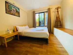 een kleine slaapkamer met een bed en een raam bij Hotel Aagaman - Best Family Hotel in Bandipur in Bandipur