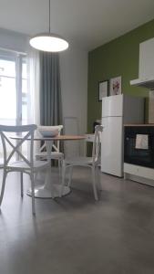 uma cozinha com uma mesa e cadeiras e um frigorífico em Casa di Monique 1 em Bari Palese