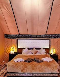 a bedroom with a large bed in a tent at Luxury Local Camp in Merzouga