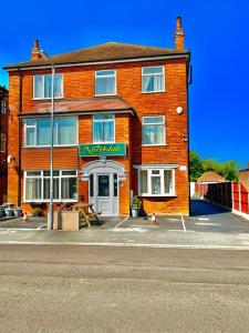 a red brick building with a sign in front of it at The Northdale Hotel Ltd in Skegness