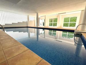 a swimming pool in a building with a table and chairs at Three bedroom apartment, PRIME Javea location in Jávea