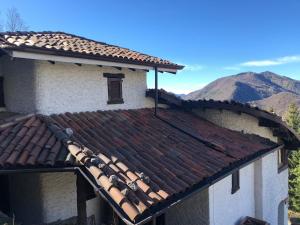 a roof of a house with mountains in the background at Camera Delux matrimoniale in Serina
