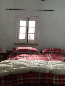 1 cama en un dormitorio con ventana en Camera Delux matrimoniale, en Serina
