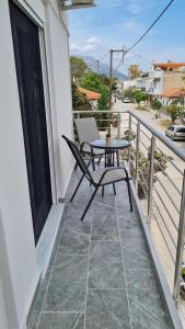 een tafel en stoel op een balkon met uitzicht op een straat bij Eretria Apartments EK9 in Eretria