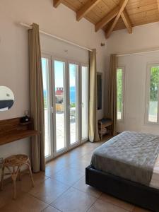 a bedroom with a bed and sliding glass doors at Villa Olivia Greece with private pool & seaview in Sivota Lefkada in Sivota