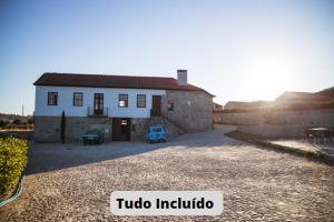 a small white house with a driveway in front of it at Quinta da Corredoura, Hotel Rural in Guimarães