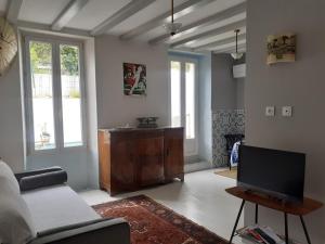 een woonkamer met een bank en een tv bij Casa azul & blanca in Banyuls-sur-Mer