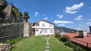 ein Haus an der Seite eines Hügels mit einer Steinmauer in der Unterkunft The Thistle Lodge in Shimla