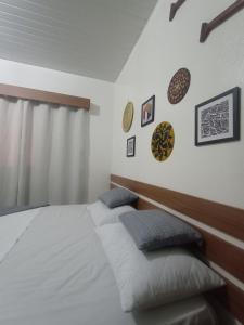 1 dormitorio con 1 cama y algunas fotos en la pared en Pousada e Hostel Coração Verde, Vários Tipos de Acomodações 300 metros da Orla, en Alter do Chao