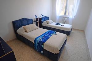 1 Schlafzimmer mit 2 Betten und einem blauen Stuhl in der Unterkunft Appartamento Bellariva B1-MyHo Casa in Porto San Giorgio
