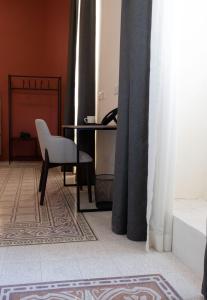 Camera con scrivania, sedia e telefono. di Mulberry Suites a La Valletta