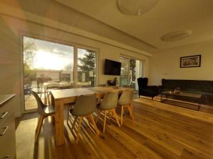 a living room with a wooden table and chairs at Dom nad jeziorem Gaja House in Jadamowo