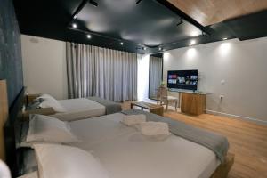 a hotel room with two beds and a flat screen tv at Porto Eda Hotel in Sarandë