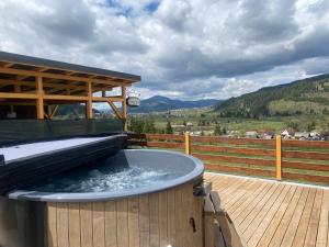 a hot tub on a deck with a wooden fence at Casa D'OR in Dorna Arini