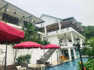 um hotel com piscina e guarda-sóis vermelhos em Sun Villa & Resort Hòa Bình - 6 em Hòa Bình