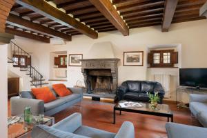 sala de estar con sofá y chimenea en Villa Castelluccio, 