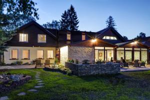 a large house with lights on a yard at Penzion Sankt Johann in Liptovský Ján