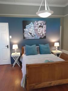 a bedroom with a bed with a painting on the wall at The French Corner on Caledon in George +2 photos