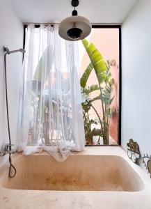 bañera en una habitación con ventana en L'Annexe-Villa patio arboré & piscine privée, en Marrakech