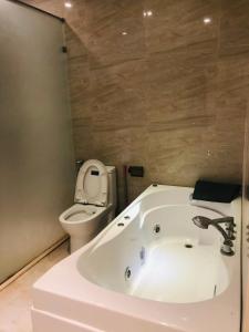 uma casa de banho com uma banheira branca e um WC. em Sun Villa & Resort Hòa Bình - 6 em Hòa Bình