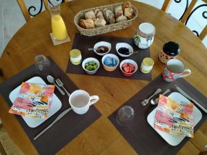 stół z talerzami żywności i kosz żywności w obiekcie La chambre de Séraphine w mieście Biscarrosse