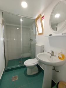 a bathroom with a toilet and a sink and a shower at La Mariana in Vama Veche