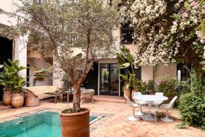 un patio con mesa, sillas y árboles en L'Annexe-Villa patio arboré & piscine privée, en Marrakech