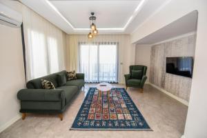 sala de estar con sofá y TV en Duygu Apart spellbinding sea views en Fethiye