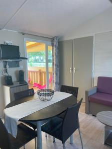 a living room with a table and chairs and a couch at Mobile home in Meschers-sur-Gironde