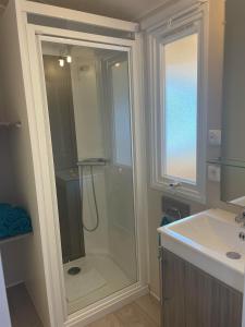 a bathroom with a shower and a sink at Mobile home in Meschers-sur-Gironde