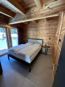 a bedroom with a bed in a room with wooden walls at Chalet Chardonnay in Kaunertal