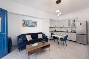 salon z niebieską kanapą i kuchnią w obiekcie Antonia's Apartments w mieście Archangelos