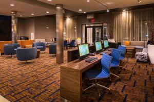 a lobby with several computers on a desk and chairs at Courtyard by Marriott Jacksonville in Jacksonville