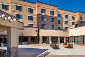 an exterior view of a hotel with chairs and tables at Courtyard by Marriott Jacksonville in Jacksonville