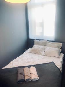 un letto con due cuscini e due asciugamani sopra di Manufaktura Apartamenty BakeryHouse PRYWATNA KAMIENICA PARKING STRZEŻONY KLIMA DOSTEP NA KOD a Łódź