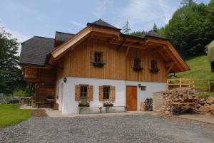 una pequeña casa con techo de gambrel y porche en Ferienhaus Leitenbauer-Huabn, en Pernegg an der Mur