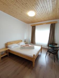 a bedroom with a large bed with a wooden ceiling at La Mariana in Vama Veche