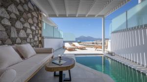 a living room with a couch and a pool at Hilltop Suites Milos in Mytakas