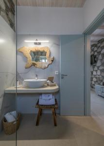 a bathroom with a sink and a mirror on the wall at Hilltop Suites Milos in Mytakas +69 photos