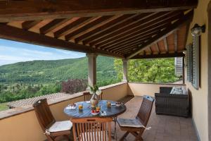 patio con mesa y sillas en el balcón en Villa Castelluccio, 