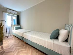 een slaapkamer met 2 bedden en een raam bij Piazza San Rocco Apartments in Corfu-stad