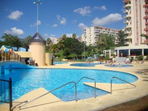 a large swimming pool with blue water in a city at Benalmadena Jupiter Sunsea View Apartments in Benalmádena
