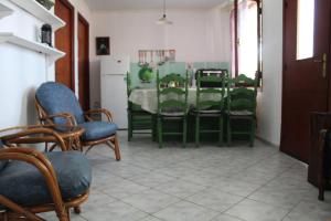 een eetkamer met stoelen en een tafel met bij Nikos Seaside Apartments in (( Litherés ))