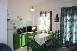 a kitchen with a table and chairs and a microwave at Nikos Seaside Apartments in (( Litherés ))