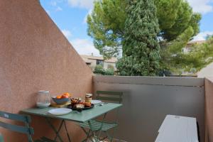 a table with a bowl of fruit on a balcony at L'écrin, Studio Cosy, MBS, Wifi, Parking, Clim in Montpellier